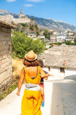 Oğluyla birlikte Osmanlı kalesi Cirokaster veya Cirokastra 'ya yürüyen bir anne. Arnavutça