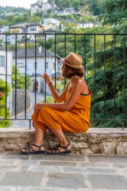 Cirokaster veya Cirokastra kentindeki bir perspektiften bakan oturan bir turist kadının portresi. Arnavutça
