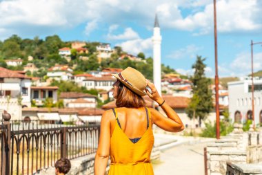 Arnavutluk 'un Berat kentinde gezen genç bir kadın, binlerce pencereli bir şehir.