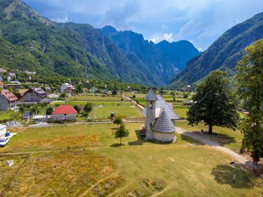 Arnavutluk 'un Theth Ulusal Parkı vadisindeki Katolik Kilisesi üzerinde hava manzarası. Alp Dağları