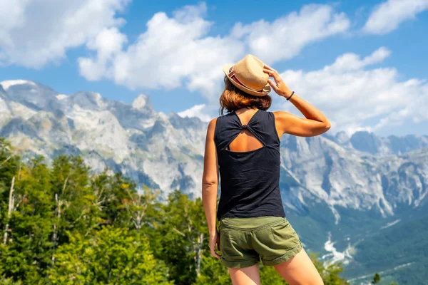 Arnavutluk 'un Theth Ulusal Park Vadisi' nin dağ zirvelerinde şapkalı bir turist kadın. Arnavut Alpleri