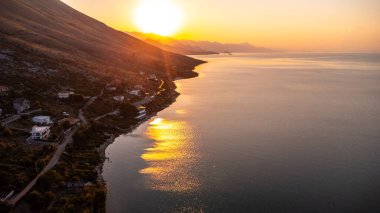 Shiroka Gölü 'nün hava aracı görüntüsü gün batımında, güneş Shkoder yakınlarındaki dağda. Arnavutluk