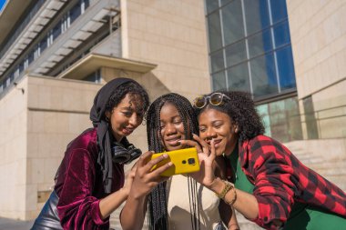 Şehirde sokakta cep telefonu kullanan çok ırklı tuhaf arkadaşlar.