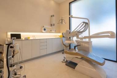 Sandalyesi ve aletleri olan bir diş kliniği çalışanı olmayan bir iç mekan.