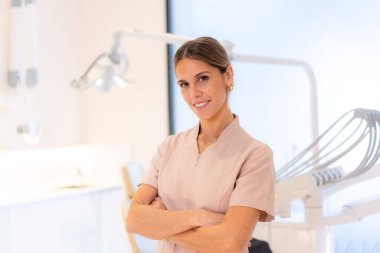 Klinikte duran gururlu bir kadın dişçinin portresi.