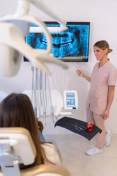 Vertical photo of a dentist explaining the results of the scan to a patient