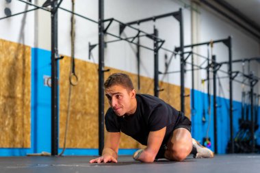 Engelli bir adam spor salonunda egzersiz yaptıktan sonra sırtını geriyor.