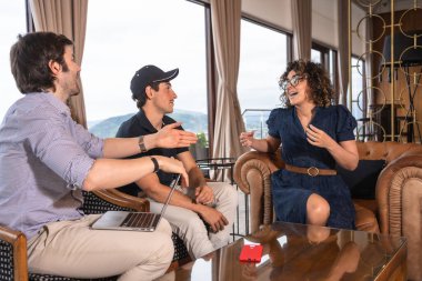 Bir otelin kafeteryasında iş arkadaşları rahatça sohbet ediyor.