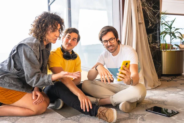 Co-workers using phone in a business meeting sitting on the floor