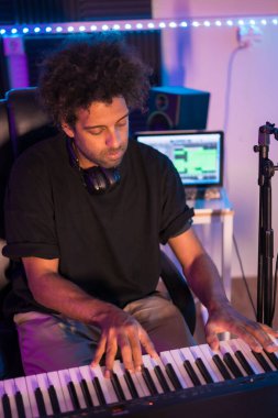 Stüdyo prodüksiyonunda müzik kaydederken bir piyanistin dikey üst görüntüsü