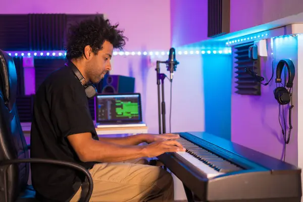 Side view of a music producer recording in a modern studio