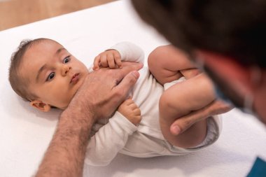 Doktorun muayenesi sırasında güzel bir bebeğin yüksek açılı görüntüsü ve yakın çekimi.
