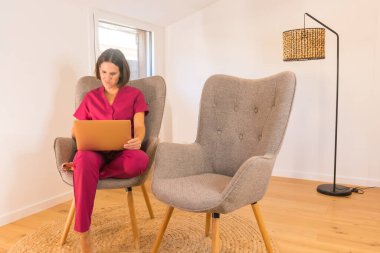 Minimalist bir yerde rahat bir kanepede evden çalışan beslenme uzmanı.