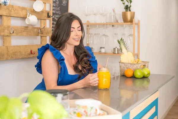 Beauty woman offering freshly made orange juice in the counter of a cafeteria