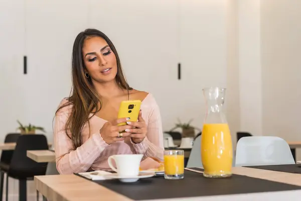 Beauty and casual businesswoman using phone while having breakfast in a luxury hotel in the morning