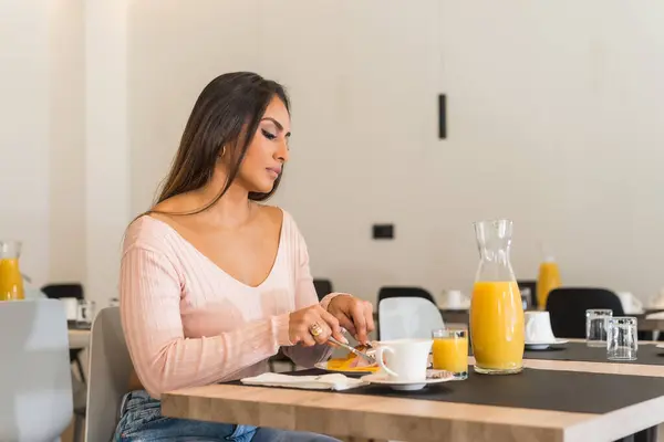 Horizontal photo with copy space of a casual businesswoman having breakfast in a buffet in an hotel