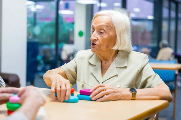 Portrait of an aged woman in a nursing home sharing skills games