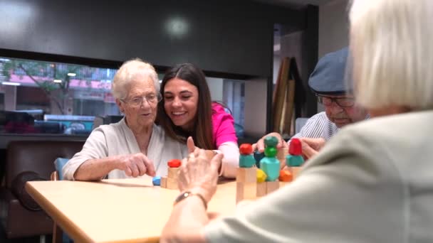 看護施設でスキルゲームをする高齢女性を支援する看護師 — ストック動画
