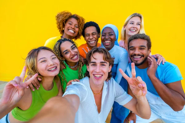 Amici Multietnici Gesticolano Successo Mentre Scattano Selfie Accanto Muro Giallo — Foto Stock