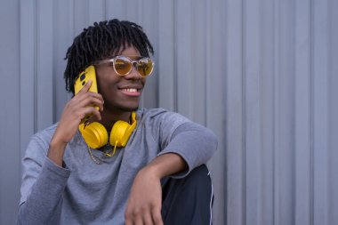 Genç bir Afrikalı adamın fotokopi çekilen portresi. Sokakta oturan cep telefonunu alıyor.