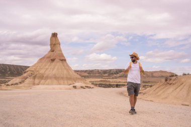 Sıradan bir adam kurak ve kumlu bir milli parkta yürüyor.