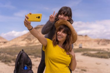 Anne ve kızı çölde bir yolculuktan sonra selfie çekiyorlar.