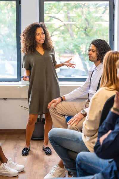 Vertical photo of a woman speaking during a meeting in a coworking