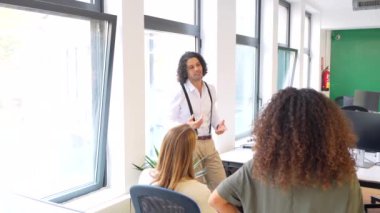 Çok ırklı gençlerle birlikte çalışan bir toplantıya liderlik eden adam.