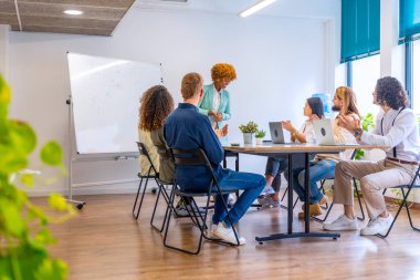 Genç bir çalışma ekibinin birlikte çalıştığı bir toplantıda fotokopi çekilen fotoğraf
