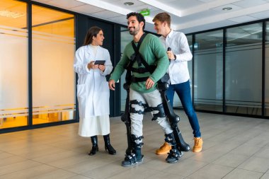 Mechanical exoskeleton, female doctor with device walking with disabled person with robotic skeleton in rehabilitation, physiotherapy in modern hospital, futuristic physiotherapy clipart