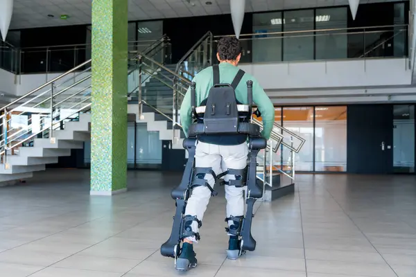 Mechanical exoskeleton, disabled person on his back walking with the help of robotic skeleton, physiotherapy in a modern hospital, futuristic physiotherapy