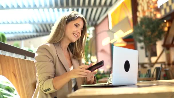 Femme Souriante Utilisant Ordinateur Portable Parlant Mobile Dans Une Cafétéria — Video
