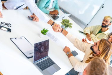 Dymanic, bir toplantıda iki adamın el sıkışırken çekilmiş bir fotoğrafı.