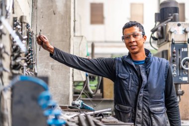 Metal endüstrisinde Latin işçiler sayısal kontrol sektöründe ticaret yapıyor, aletleri topluyor.