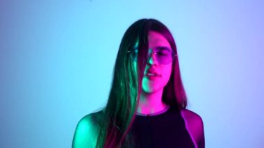 Uzun saçlı, güneş gözlüklü, neon ışıklarla dans eden şehvetli bir transseksüel.