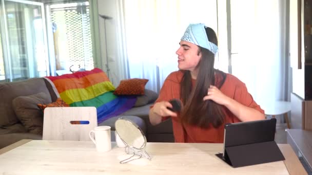 Transgender Person Beim Bürsten Der Langen Haare Mit Tablet Wohnzimmer — Stockvideo