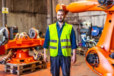 Portrait of a mechanic in uniform in an industry that build robotic arms clipart