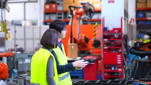 Инженеры Мультикультурники Занимаются Бумажной Работой Сборочной Линии Производства Роботизированного Оружия — стоковое видео