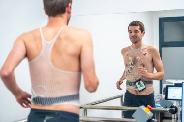 Adam hastanede kardiyovasküler stres testi yaparken koşuyor.