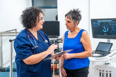 Hastanedeki ekokardiyogramdan sonra kardiyolog bir hastayla konuşuyor.