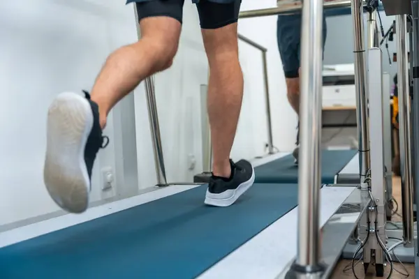 Legs of a patient performing a cardiovascular stress test walking on a treadmill