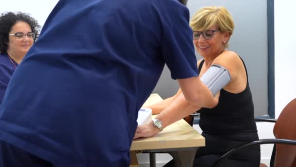 Usmívající Dospělá Žena Sedící Během Vyšetření Krevního Tlaku Kardiologické Klinice — Stock video