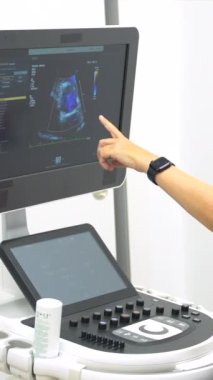 Hastanedeki bir hastaya ekokardiyogram yapan kadın kardiyolog.
