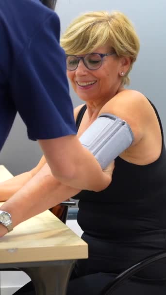 Mujer Madura Sonriente Sentada Durante Examen Presión Arterial Una Clínica — Vídeo de stock