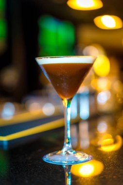 Lüks bir barın tezgahındaki Martini kokteylinin dikey fotoğrafı.