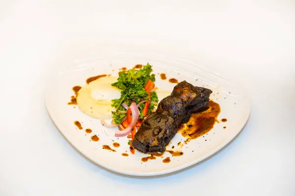 Delicious and luxury dish of Short Ribs of Beef on a white table