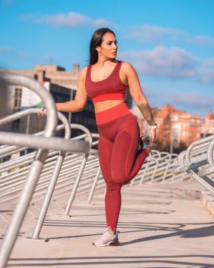 Açık hava parkında bacaklarını açan sağlıklı bir kadının ön görüntüsü.