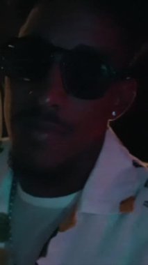 Müzik kayıt stüdyosunda çalışan konsantre ses mühendisi ya da yapımcının portresi. Güneş gözlüklü zenci bir müzisyen.