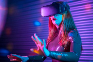 Fütürist bir alanda neon ışıklı VR gözlükleri kullanarak boş zaman oyunları