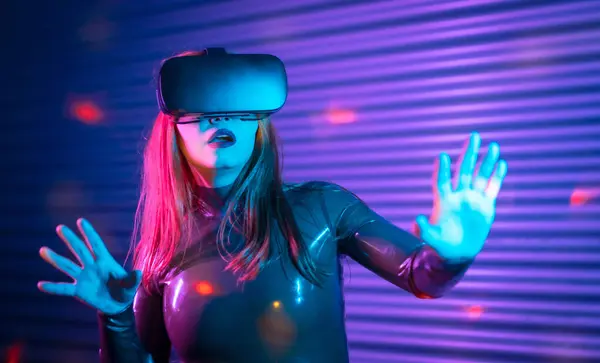 Shocked woman using augmented reality goggles in a futuristic space at night space with neon lights